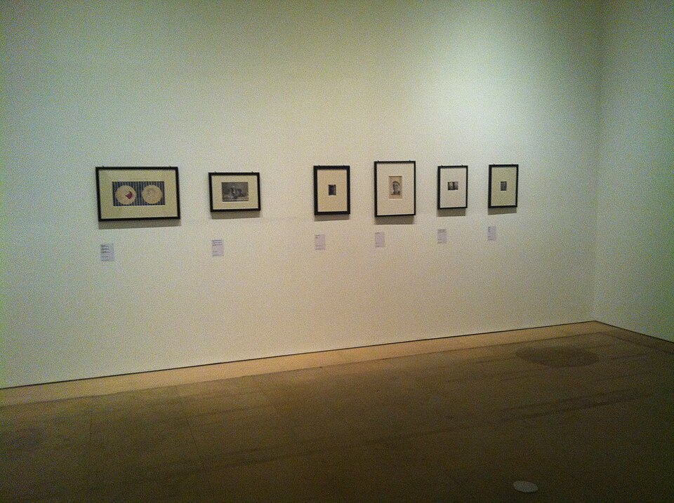 Gallery wall with framed Claude Cahun photomontages and surrealist objects at the Palau de la Virreina, Barcelona, 2012