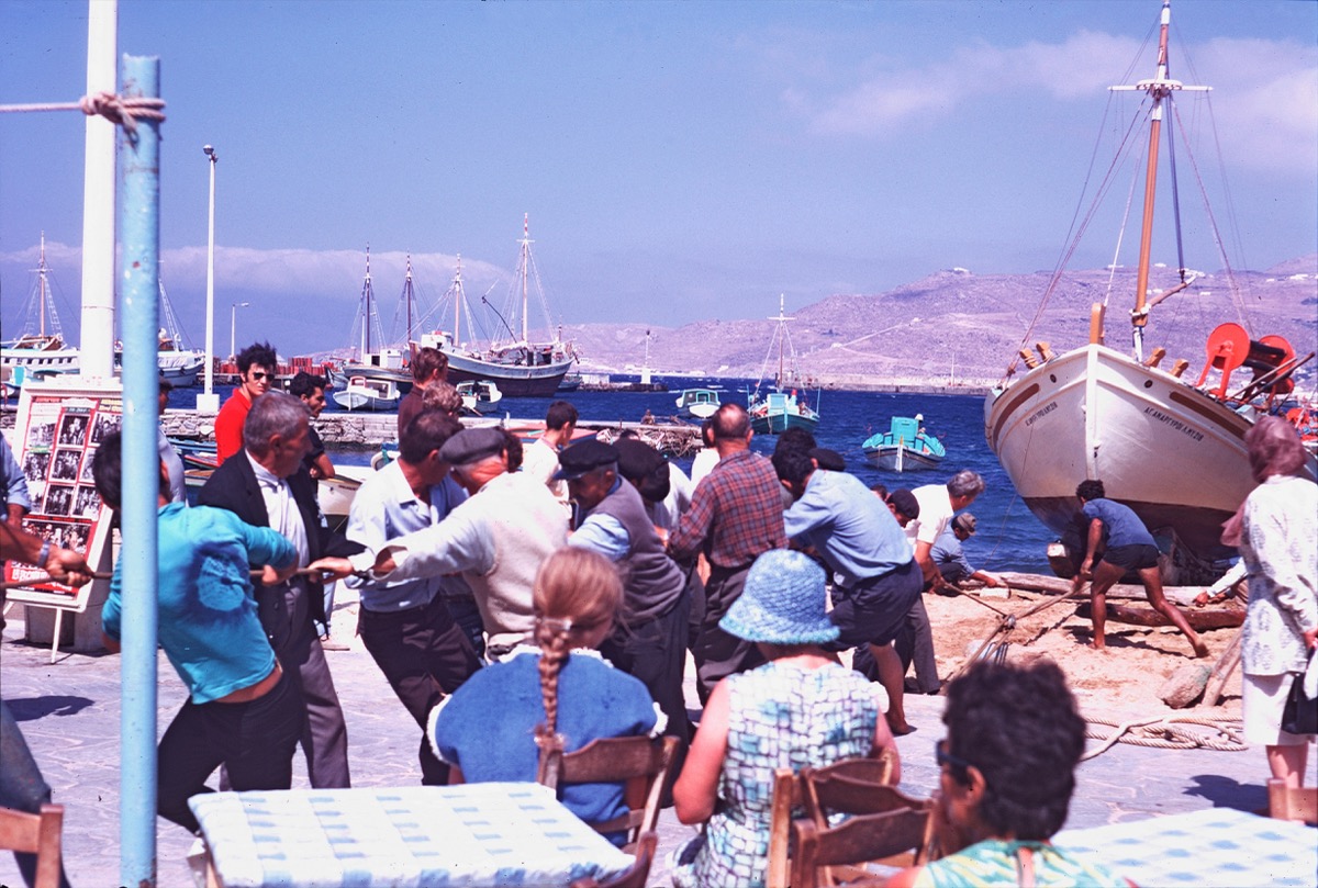 A fishing boat being pulled ashore on Mykonos, Greece, reminiscent of Manos's Greek Portfolio documentation of island life