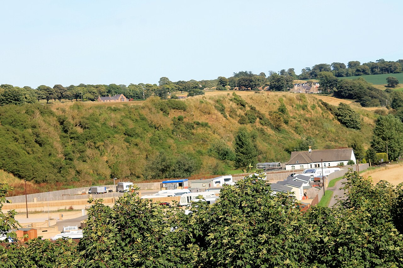 Travellers camp with caravans in rural landscape