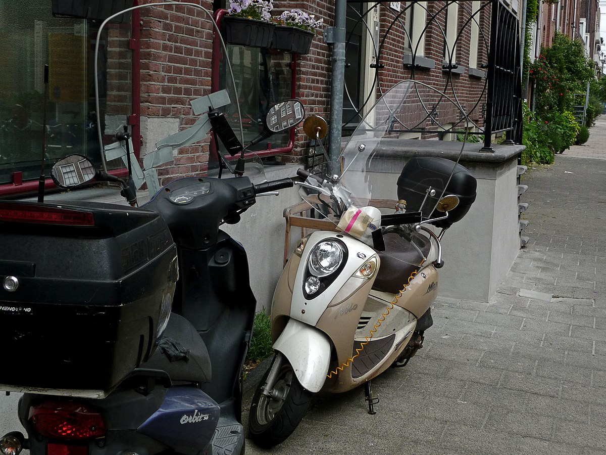 Urban street still life — parked mopeds creating an accidental arrangement, the kind of found composition Harvey Benge celebrated