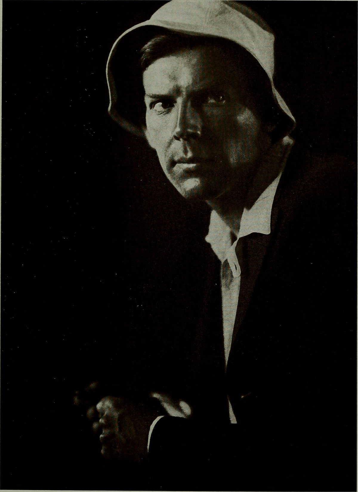 Dramatic portrait of a hooded figure with theatrical lighting by Helmar Lerski, from The American Annual of Photography, 1914