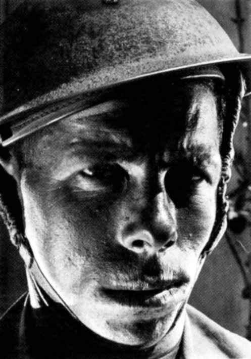 Dramatic close-up of a Jewish soldier with helmet lit from below by Helmar Lerski, 1942-43