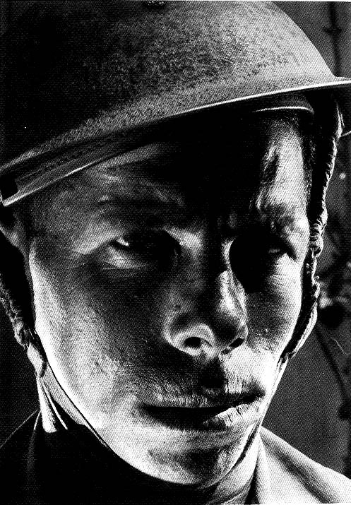 Close-up portrait of a Jewish soldier with helmet and dramatic reflected light by Helmar Lerski, 1942-43