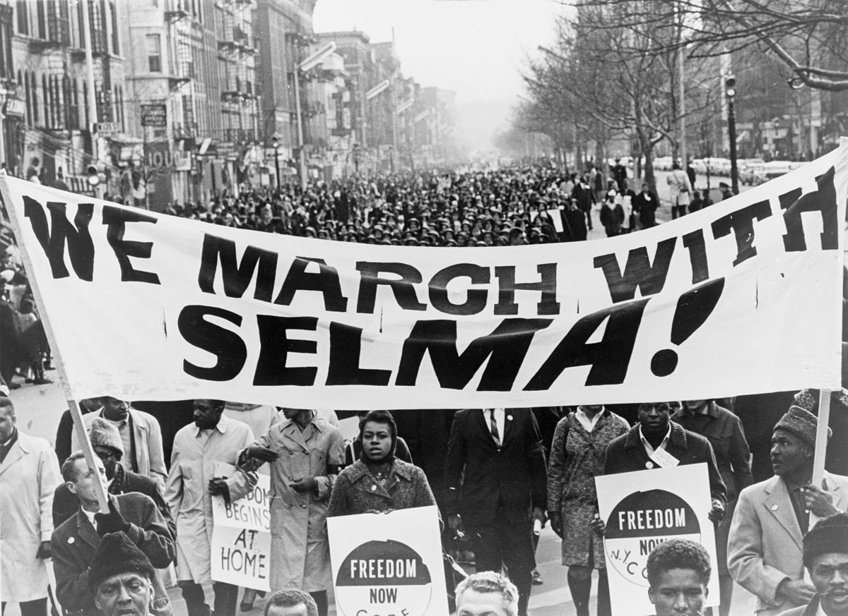 Civil rights marchers carrying 'We March with Selma' signs in Harlem, New York, 1965