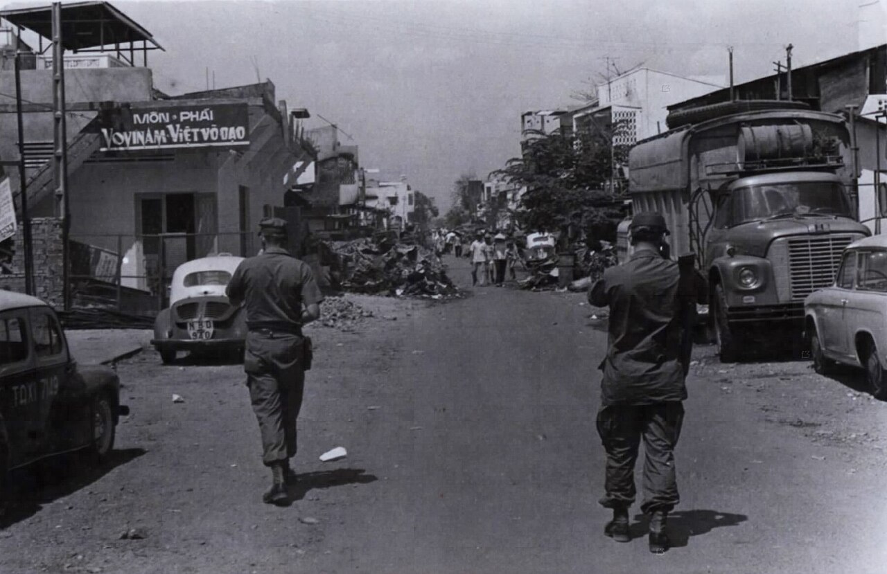 US military personnel walk through the destroyed Cholon district after the Tet Offensive
