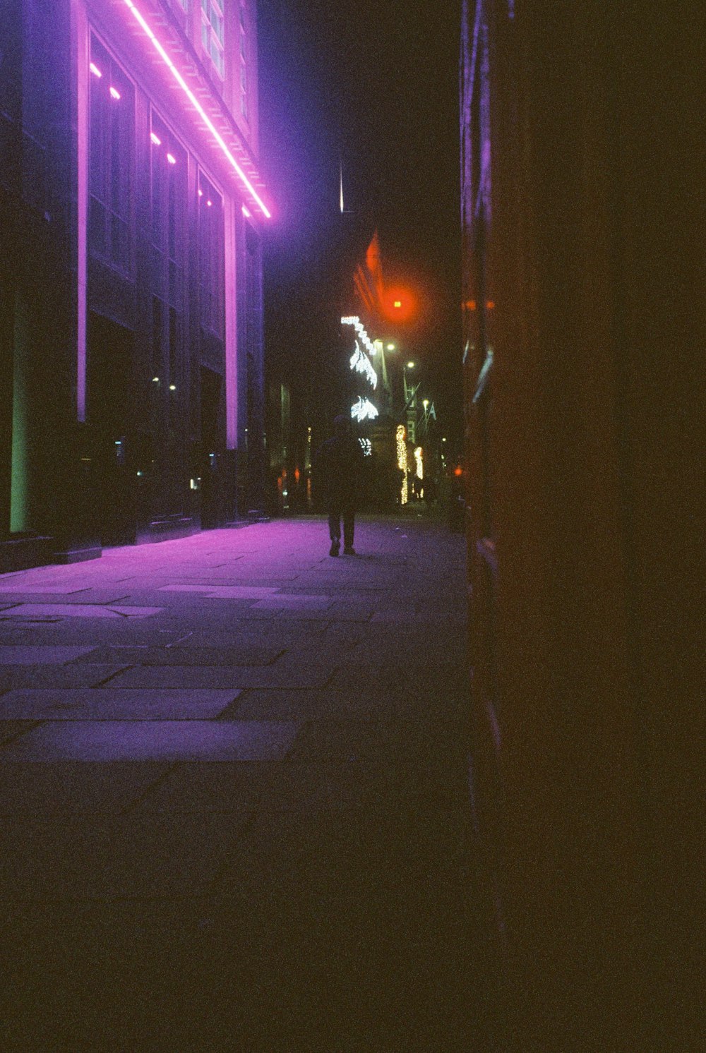 Lone figure on a neon-lit city street at night, evoking diCorcia's Hustlers series on Santa Monica Boulevard