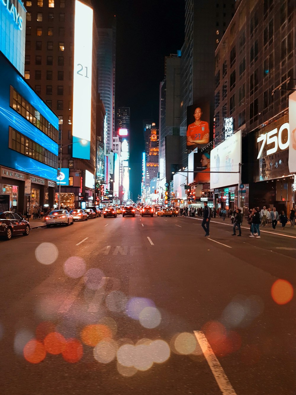 Times Square at night with pedestrians and city lights, evoking diCorcia's Heads series location