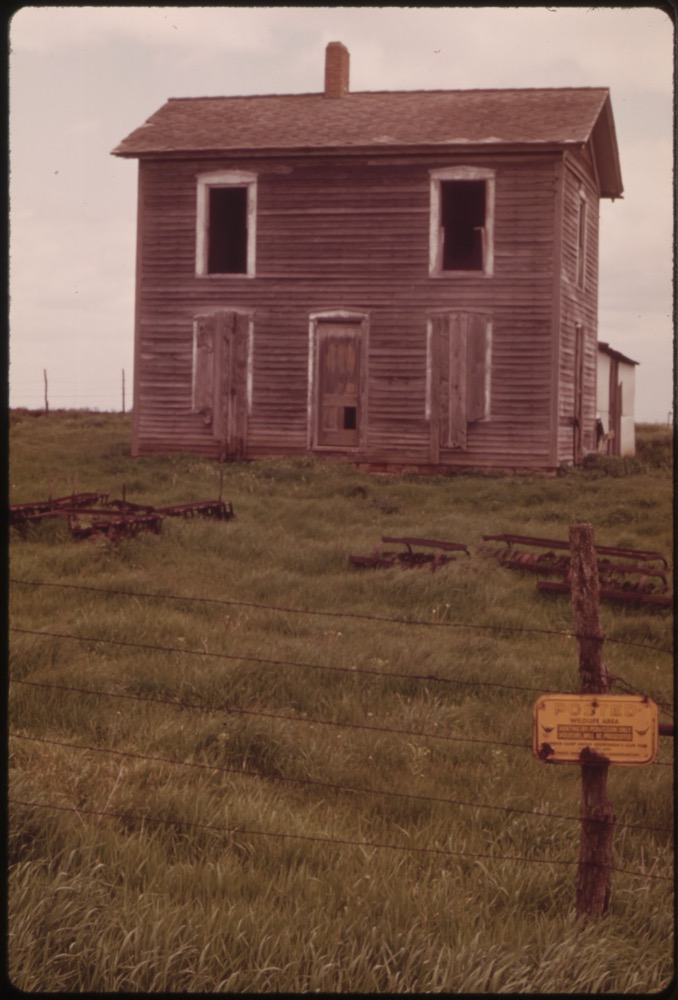 Abandoned farmhouse with empty windows, evoking the rural settings of Meatyard's photographs