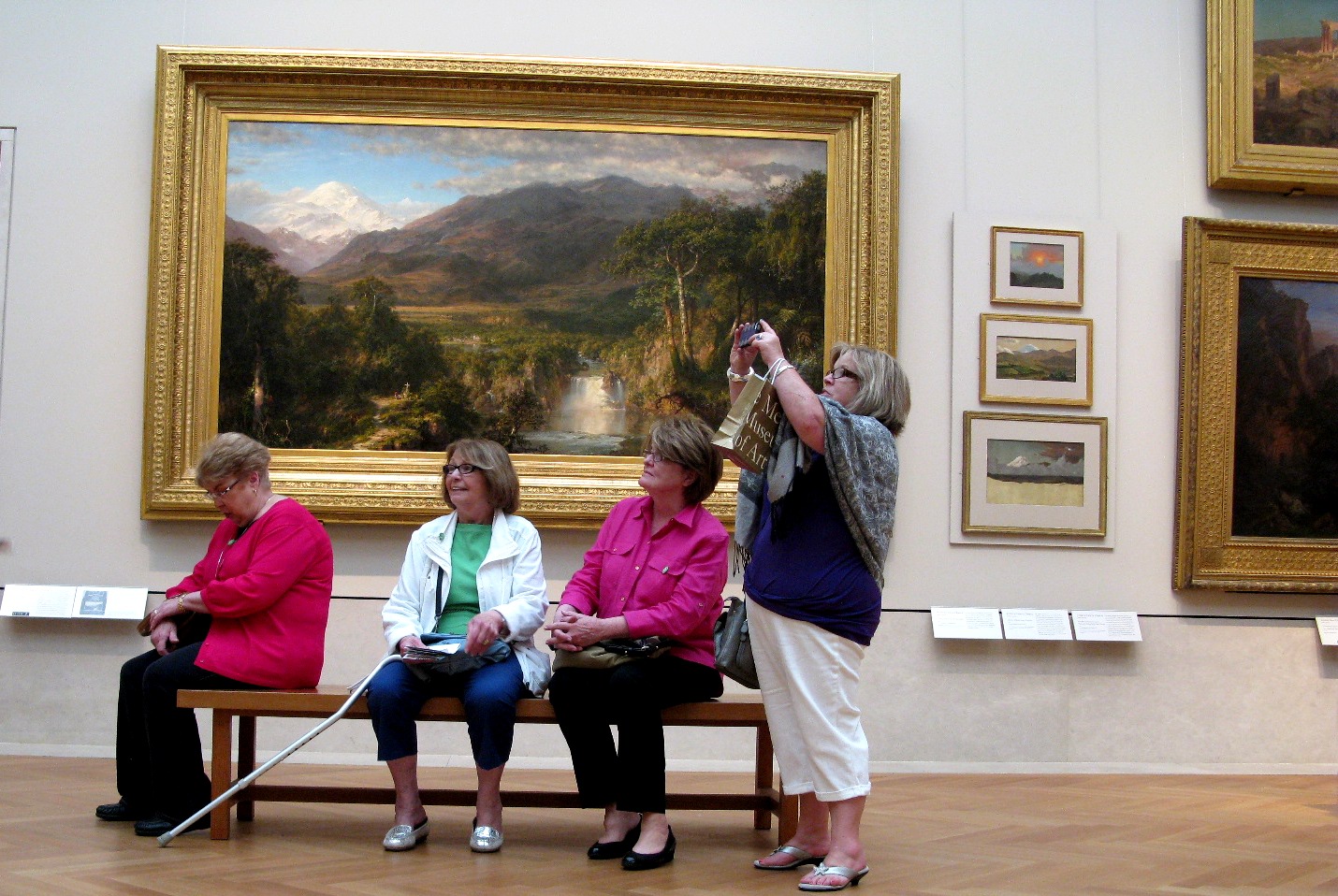 Visitors contemplating paintings in a museum gallery, evoking Thomas Struth's Museum Photographs series