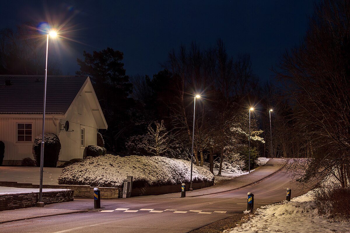 House by a road at night in Tuntorp, Sweden, moonlit snow on the ground — evocative of Todd Hido's House Hunting series